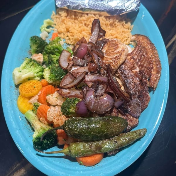 El Molino's Mexican dish with grilled meat, onions, rice, mixed vegetables, and two green chili peppers.