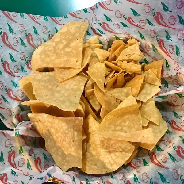 A basket of crispy tortilla chips sits on chili pepper-patterned paper at El Molino.